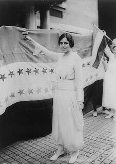 Black and white photo of Alice Paul in a white dress during the early 1900's- a color that was worn by Suffragists.